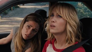 Rose Byrne and Kristen Wiig looking out the car window in Bridesmaids.