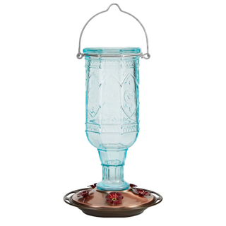 A light blue and copper glass and metal hummingbird feeder