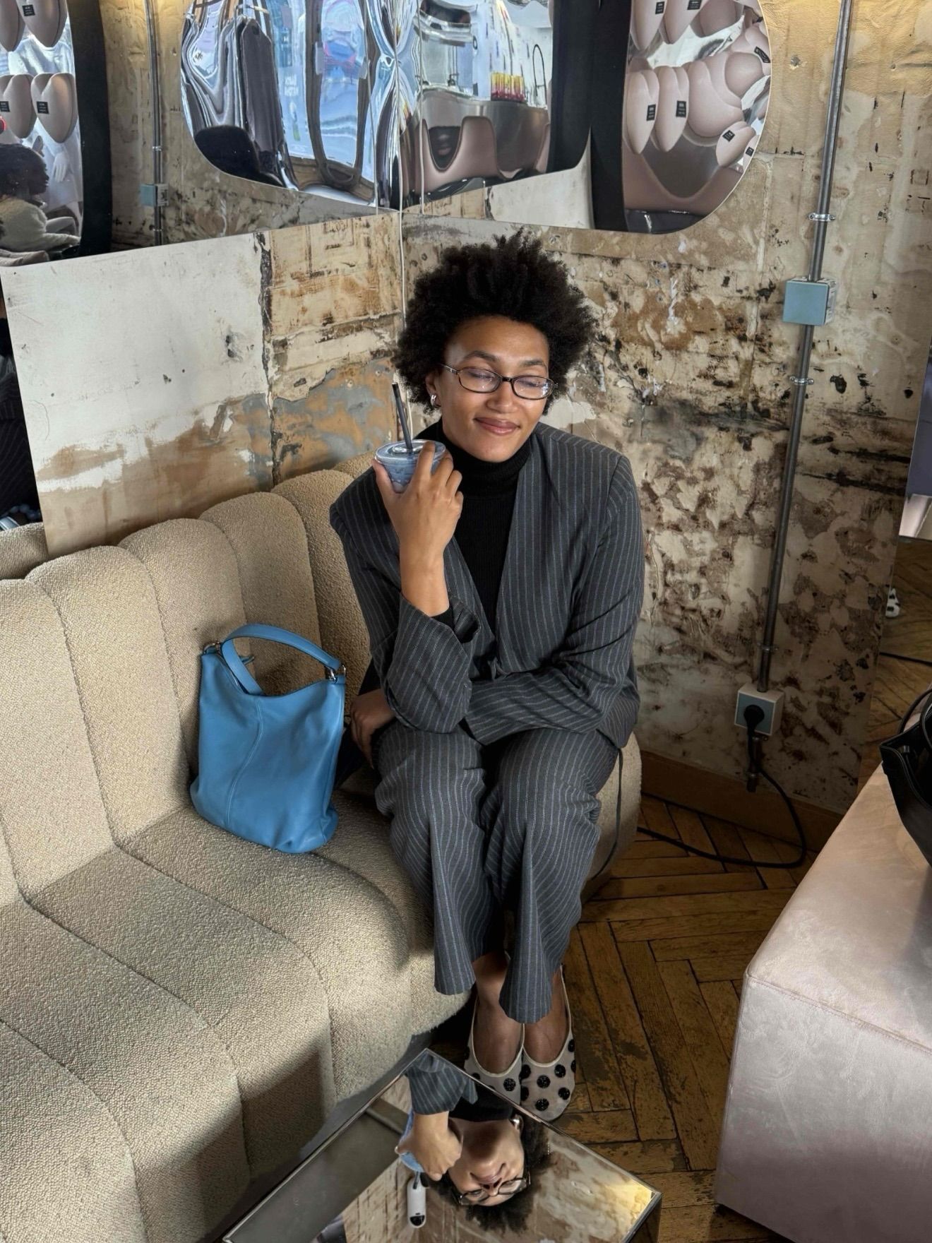 An image of @lenafarl wearing polka-dot flats with a pinstripe suit.