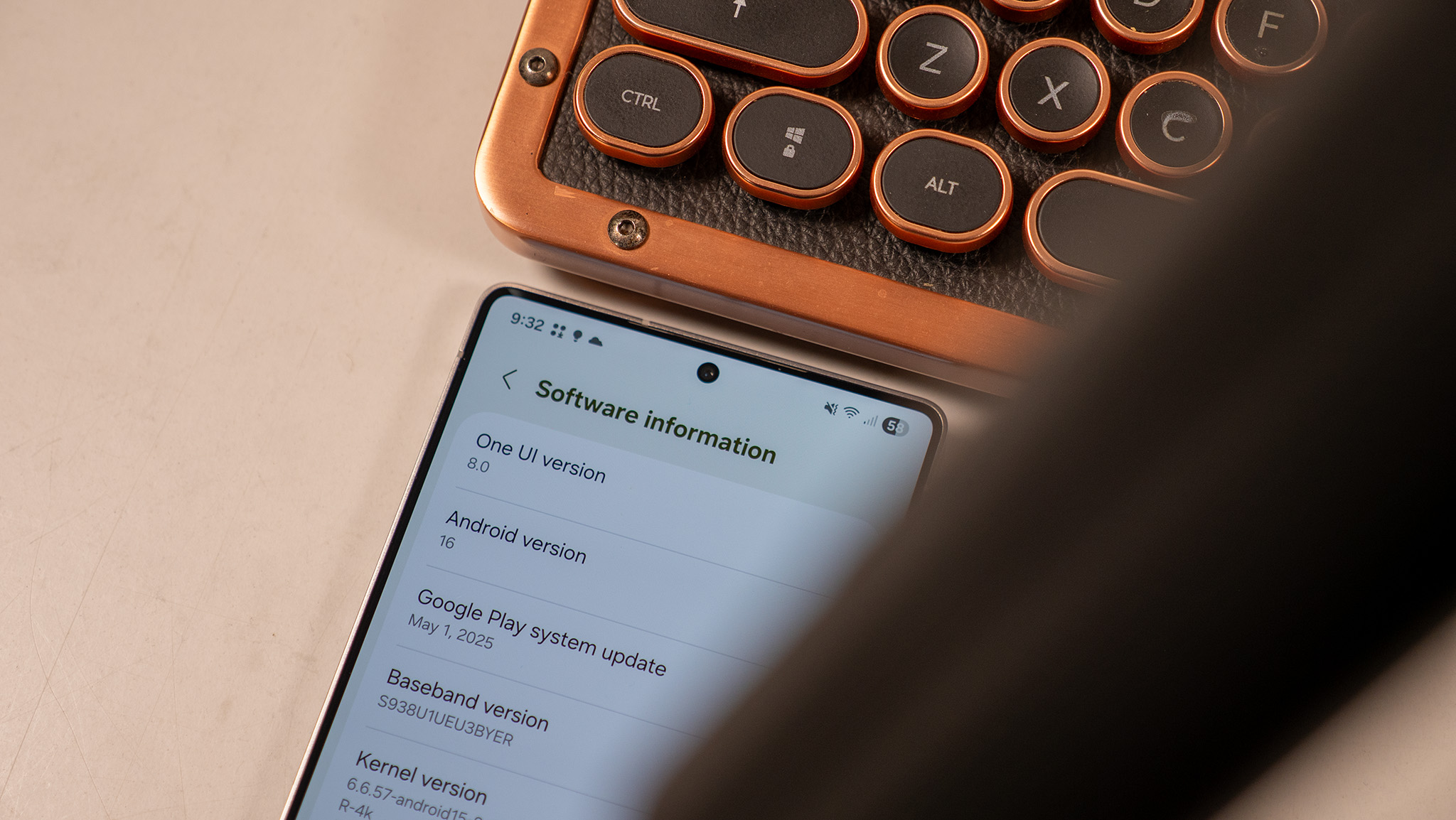 A Samsung Galaxy S25 Ultra running One UI 8 next to a copper mechanical keyboard