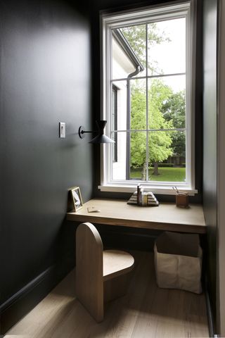 A window seat with brown furniture and black walls