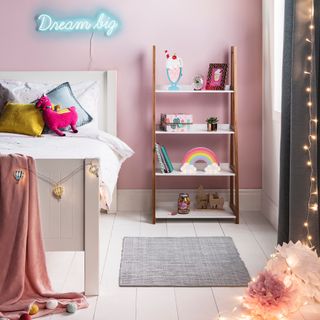Pink kids room with wooden floor, bookcase and neon lighting