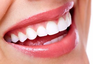 A woman smiles, revealing her teeth.