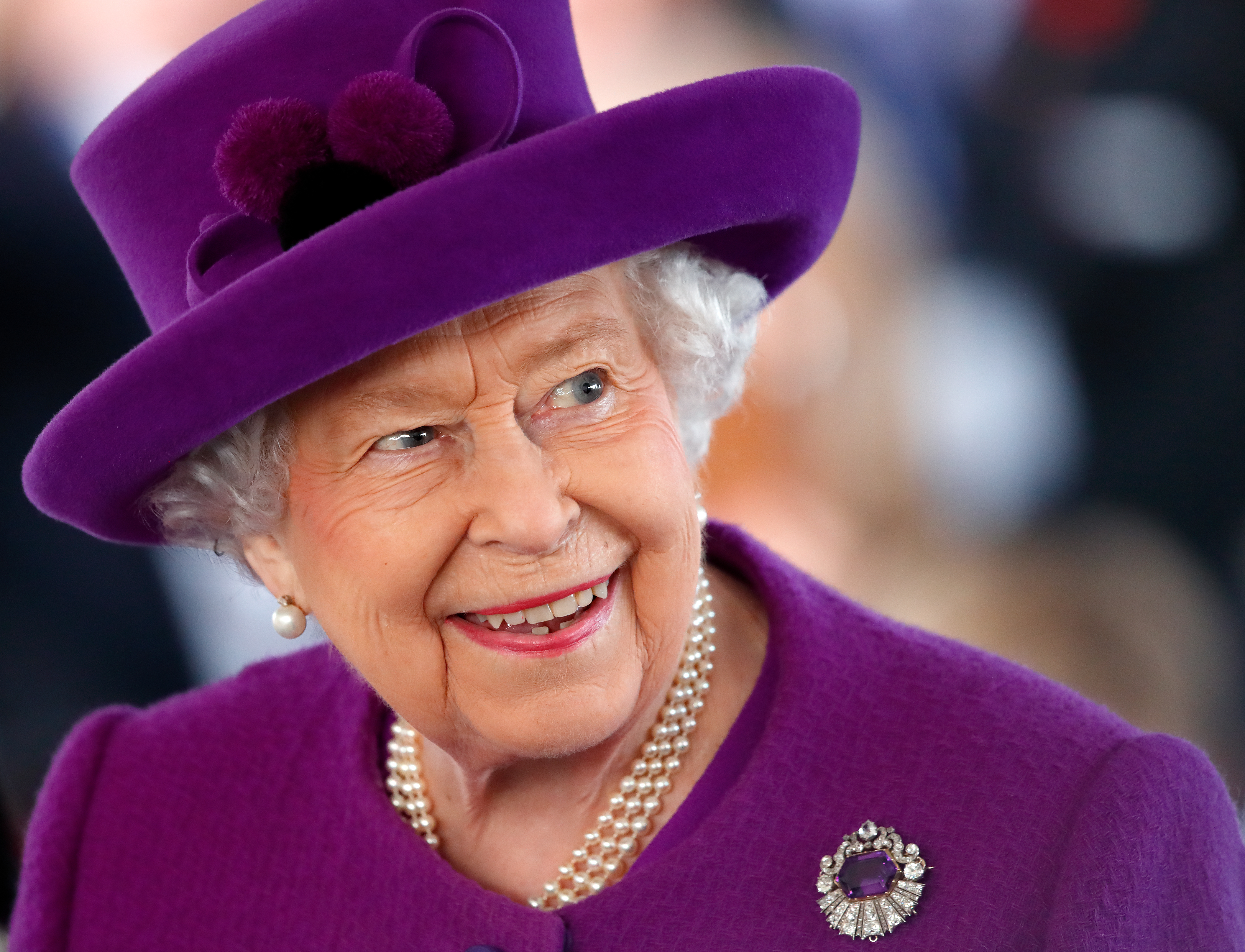 Queen Elizabeth in a purple coat and hat