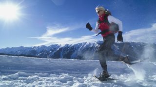 A woman running in snowshoes