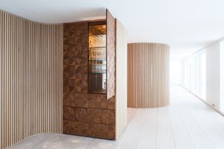 A walnut cupboard, in the dining area, is cut in a bespoke pattern, also used for copper door-handle details.