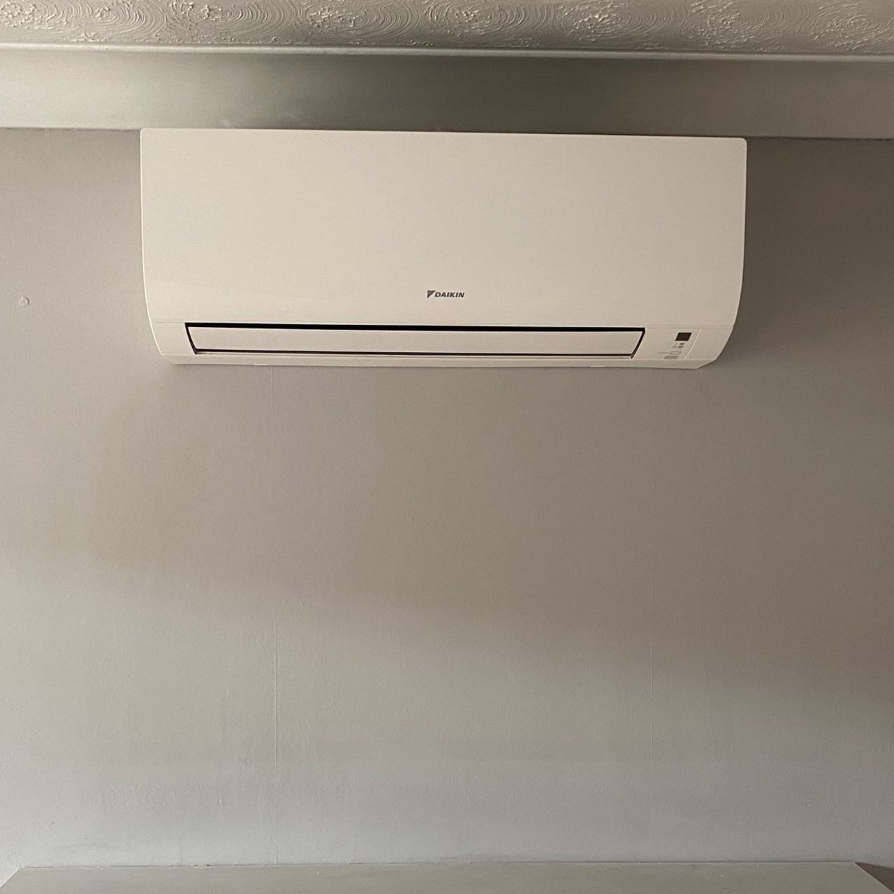 Daikin air conditioning unit mounted on a wall in the living room