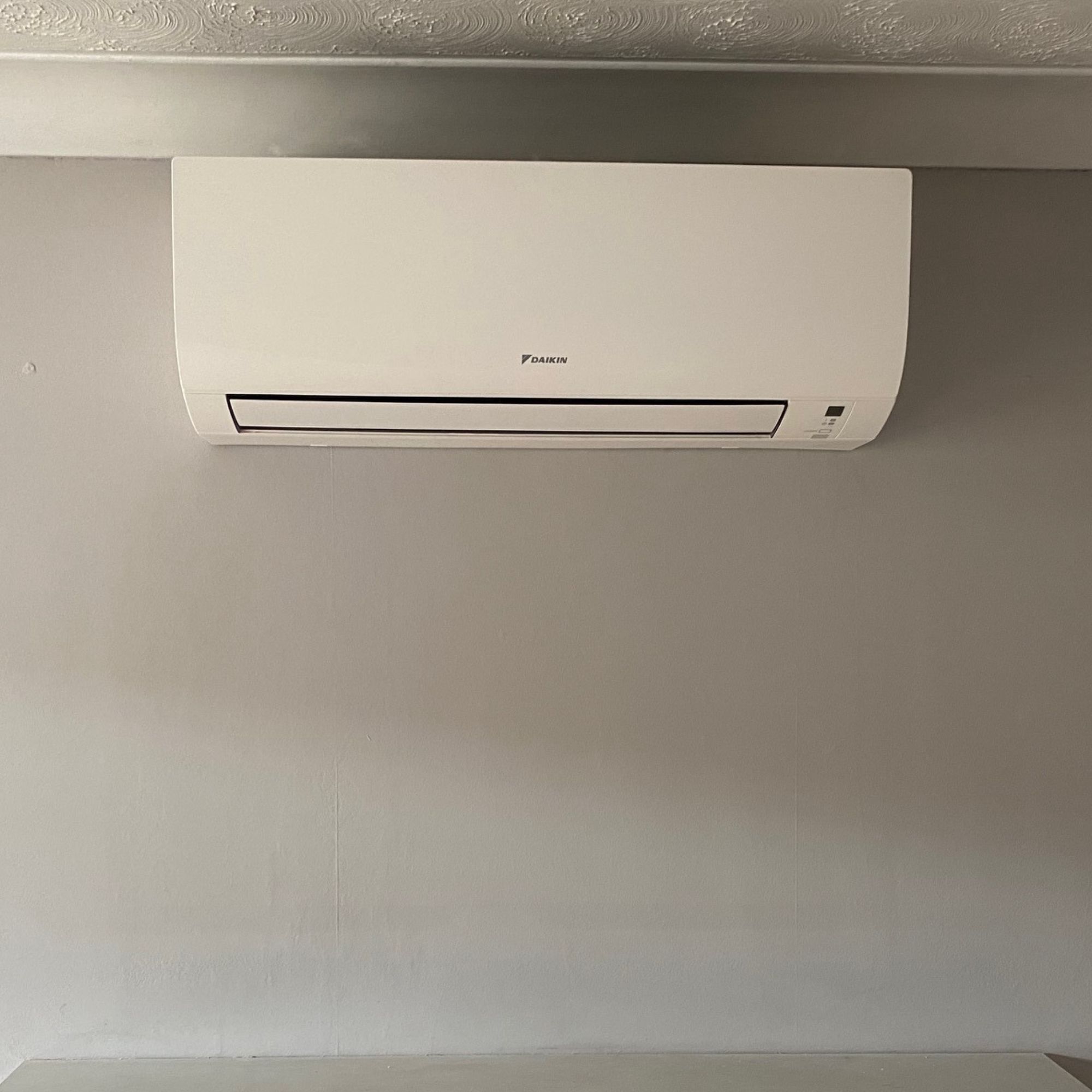 Daikin air conditioning unit mounted on a wall in the living room