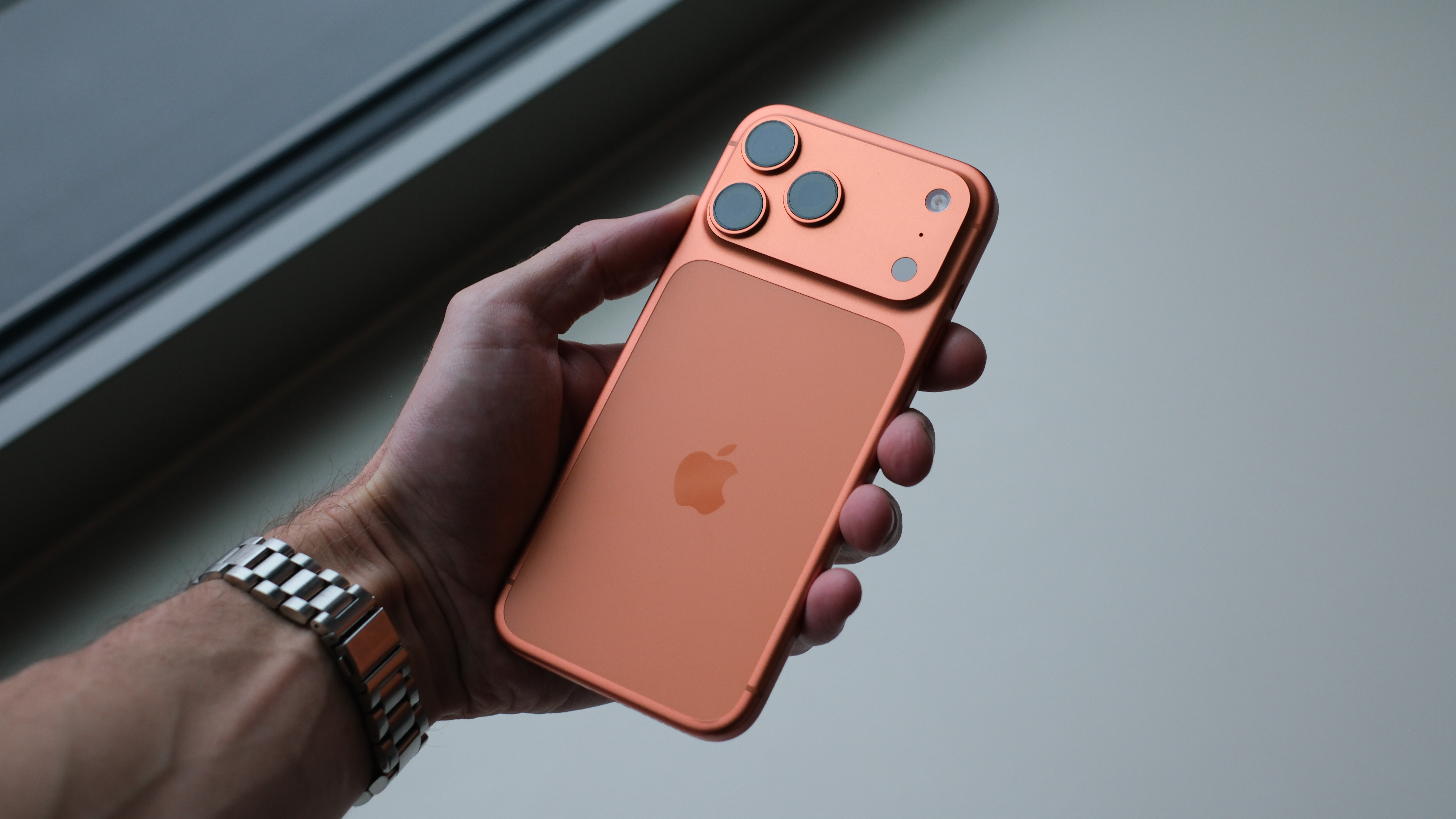 Apple iPhone 17 Pro Max in orange held in a hand