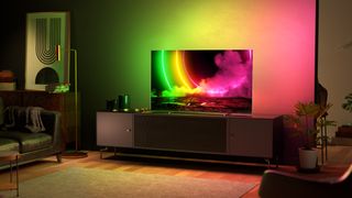 Philips OLED806 on TV bench with Ambilight in use