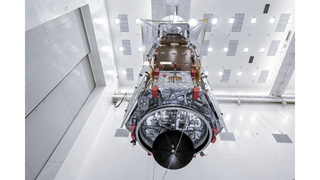 The Roman Space Telescope hangs in the clean room.