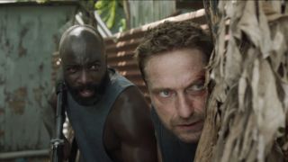 Mike Colter and Gerard Butler take cover by a tree in Plane.
