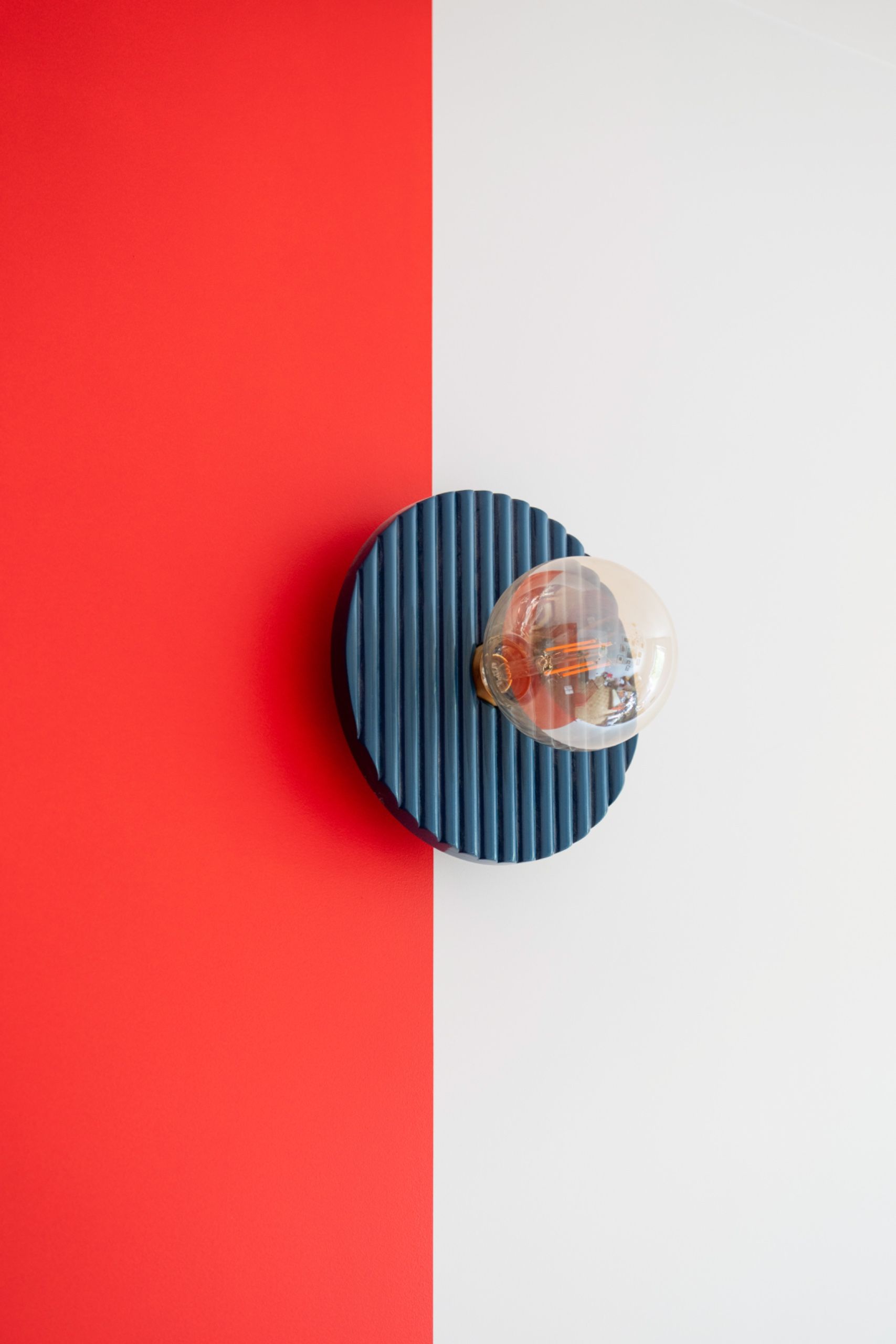 A light fixture against a color-blocked wall
