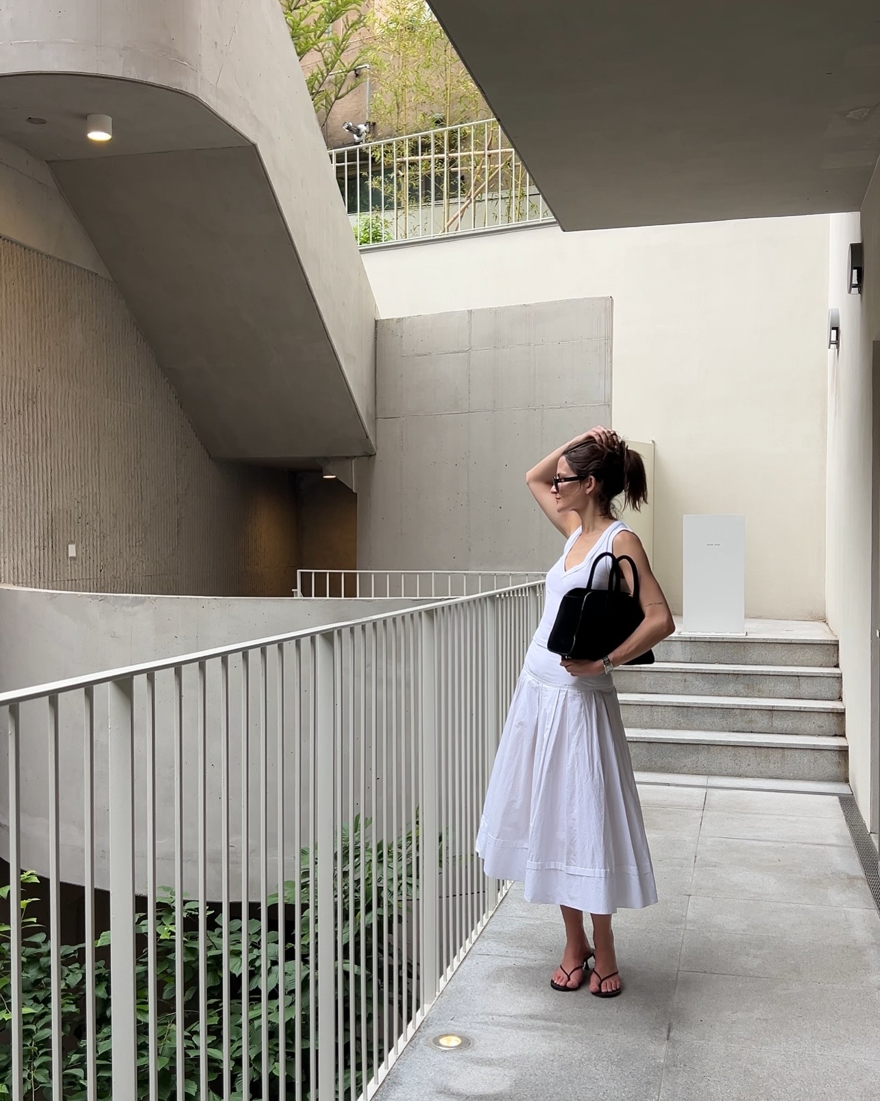 Eliza Huber in Seoul, South Korea wearing a white Zara tank top, COS bag, and white Lafayette 148 skirt.