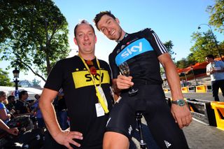 Team helper Stefan Szrek and Bernhard Eisel toast with champagne on the Champs Elysees