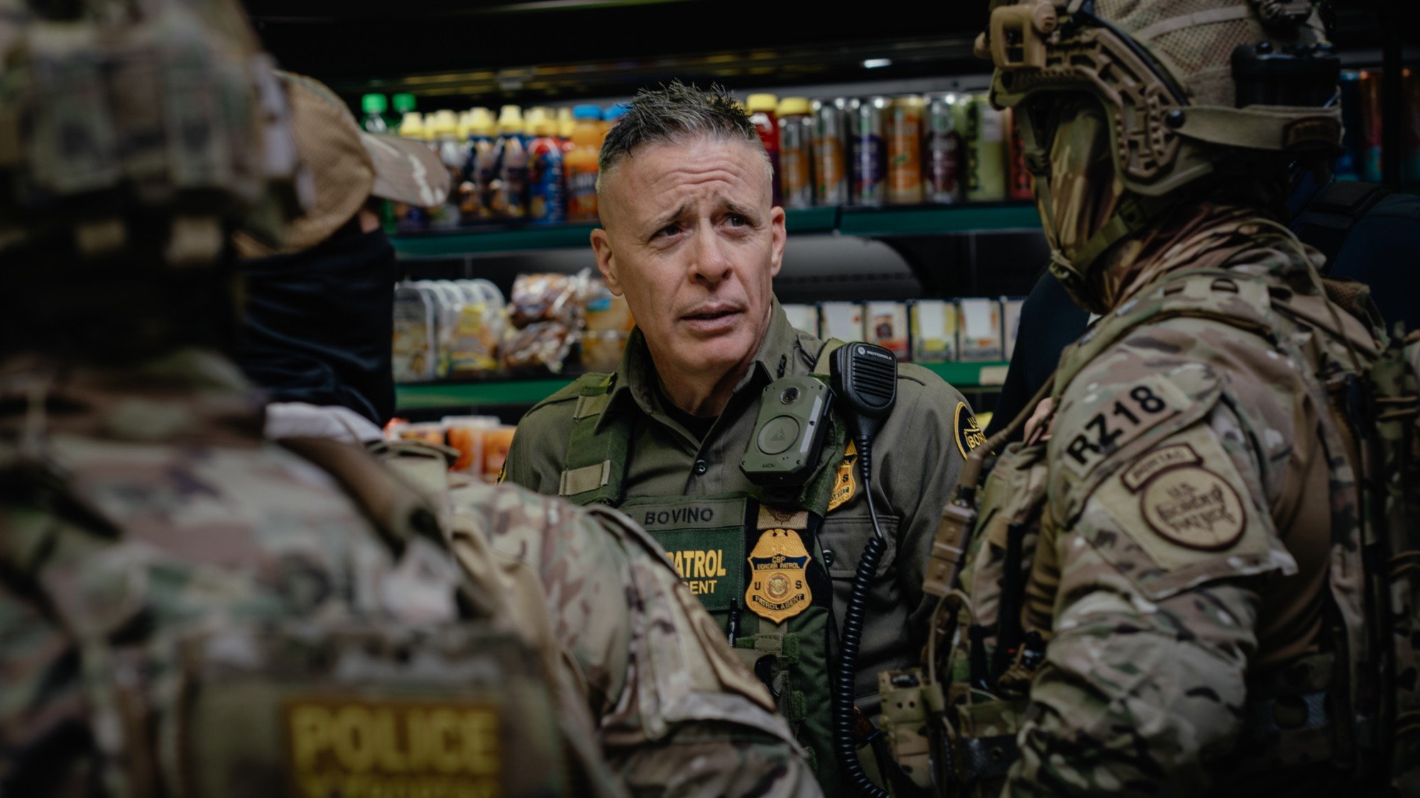 Gregory Bovino talks with other Border Patrol agents in a Chicago gas station.