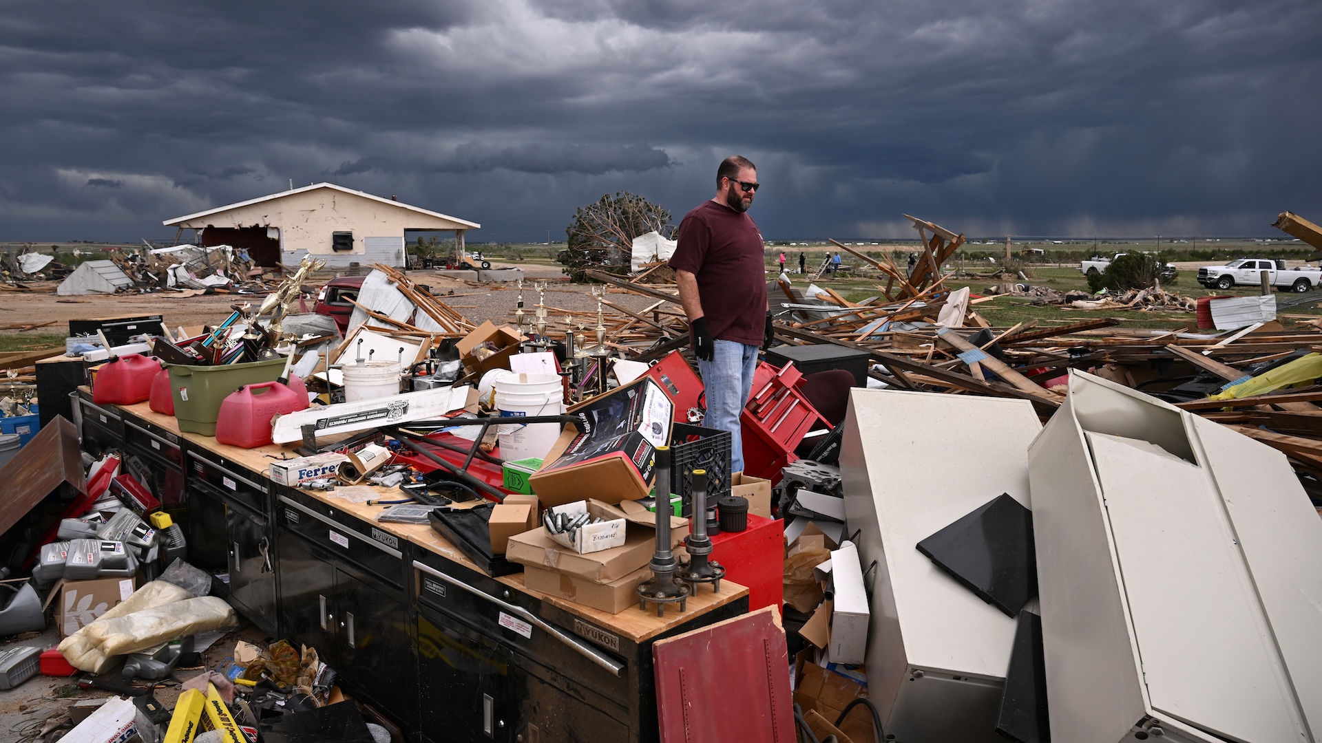 a man stands in the wreckage of a home