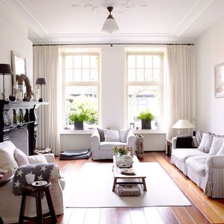 living room with wooden flooring and white and grey sofa set
