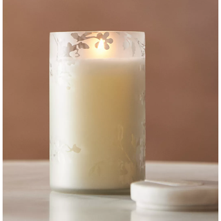 candle in a tall frosted floral jar