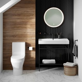 Bathroom with wood panel behind toilet and black tiles behind sink