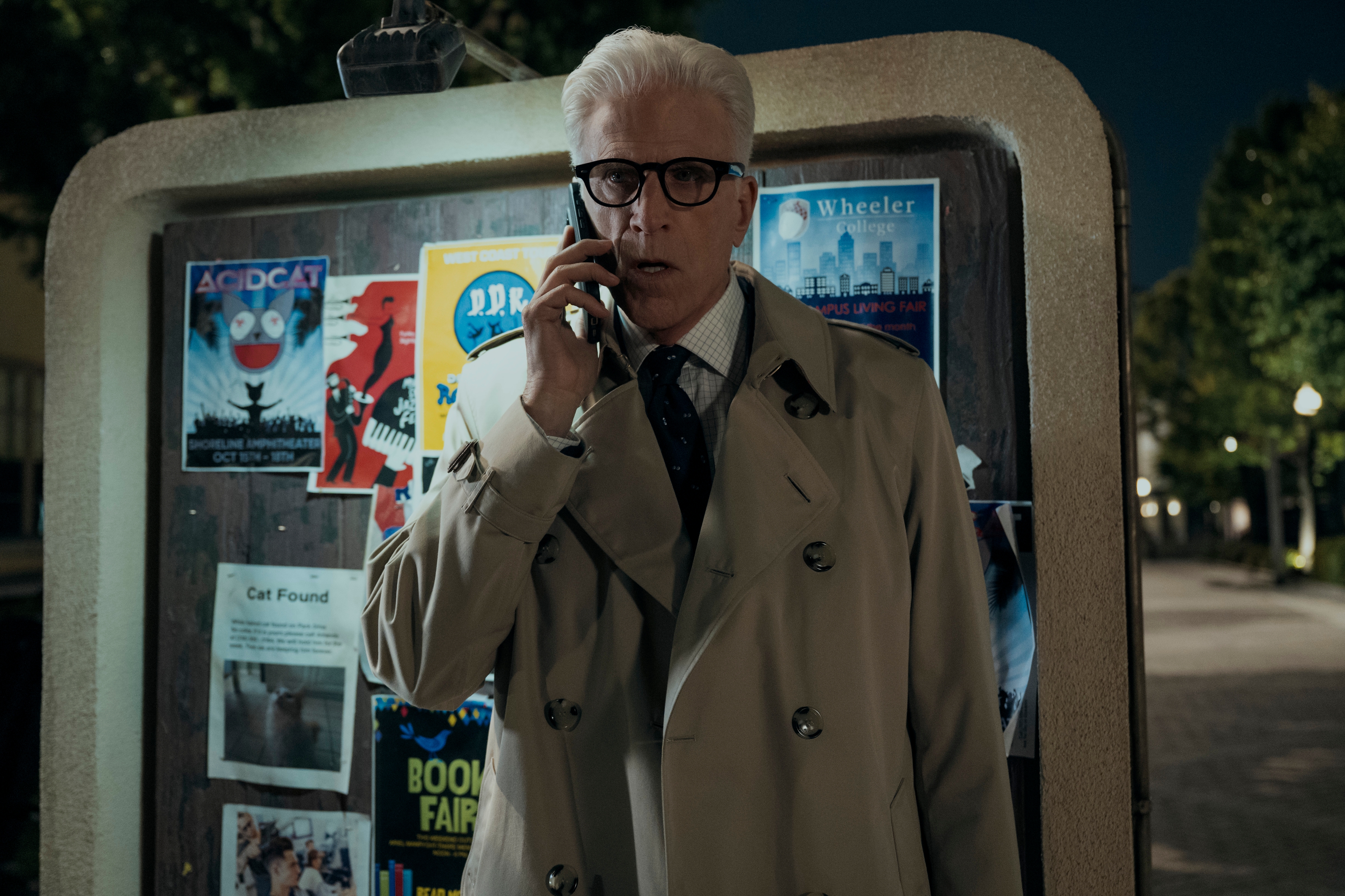 Ted Danson as Charles in episode 206 of A Man on the Inside wearing a trench coat on the phone outside of a campus