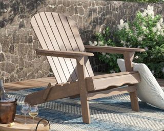A wooden Adirondack chair on a decked patio