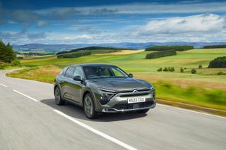 Citroën C5 X on the road amid green fields