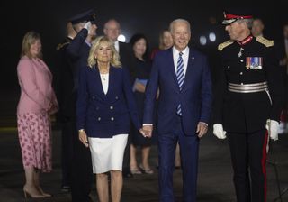 U.S. President Joe Biden, center, and U.S. First Lady Jill Biden, left, are escorted as they arrive to attend the Group of Seven Leaders Summit, in Newquay, U.K., on Wednesday, June 9, 2021. As he prepares to host the G-7 summit in southwest England this week, U.K. Prime Minister Boris Johnson is benefiting from Biden's commitment to teaming with other countries in the face of unprecedented threats following the disruption of the Donald Trump era. Photographer: Neil Hall/EPA/Bloomberg via Getty Images