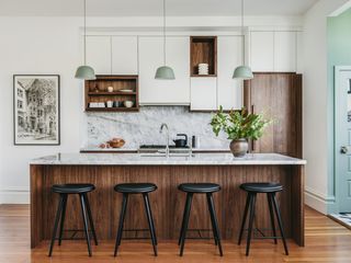 white kitchen with wood kitchen island and marble backsplash by Banner Day Interiors