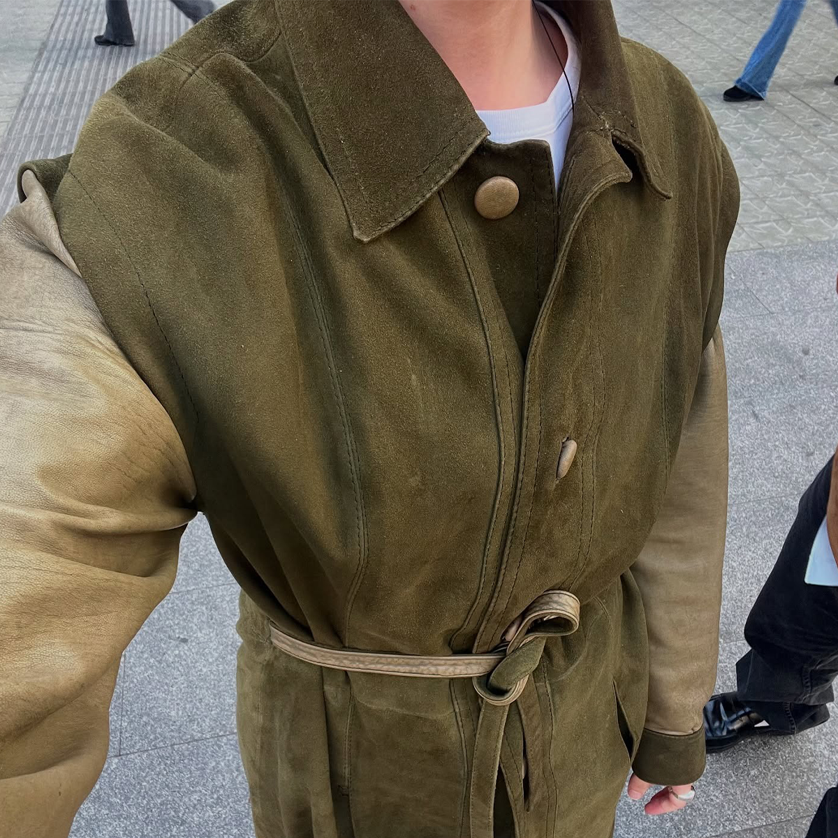 Madrid woman wearing olive green suede jacket.