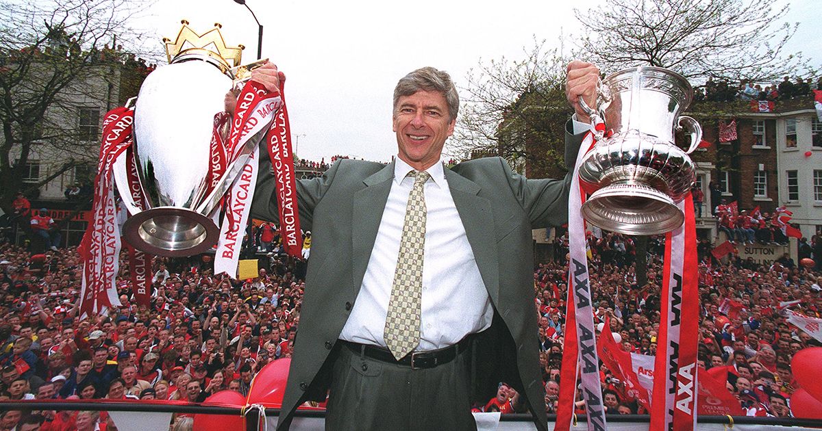 Arsene Wenger the Arsenal manager with the Premier League trophy and the FA Cup trophy during the Arsenal Trophy Parade on May 12, 2002 in London, England.