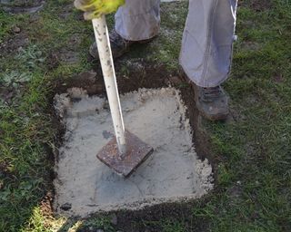 Tamping sand to act as a foundation for a stepping stone path