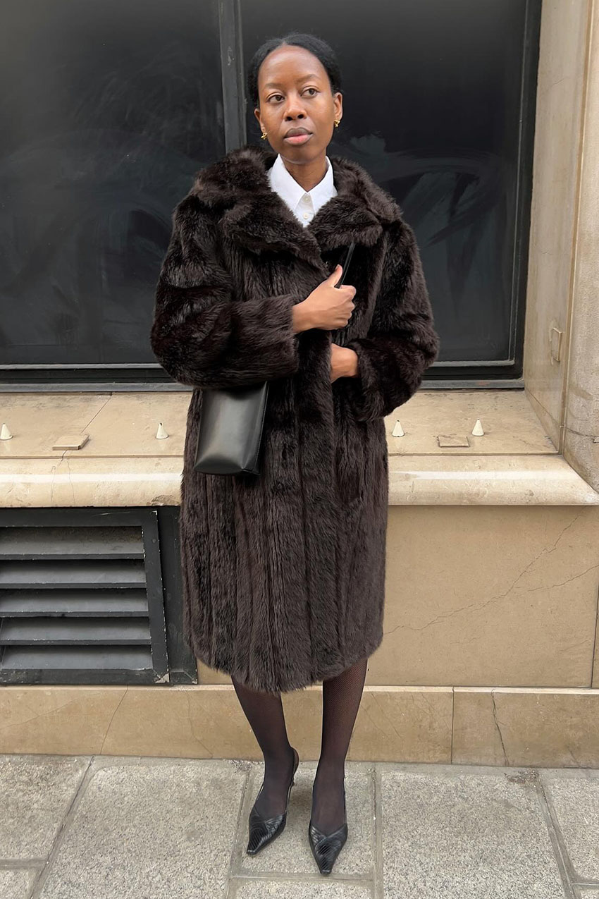 a woman wearing a brown coat and tights