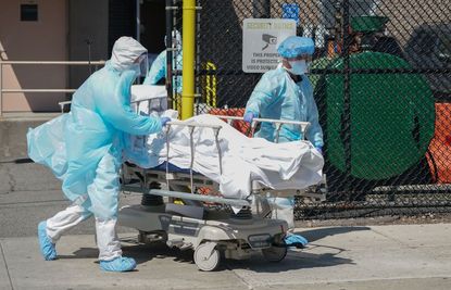 Hospital workers move a body.