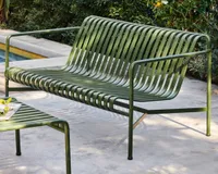 A green metal garden bench on a pool terrace
