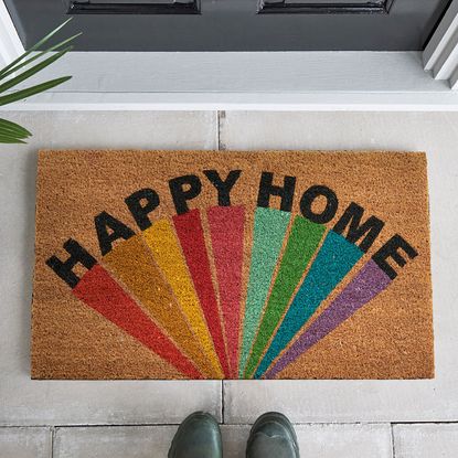 black door with doormat and shoes