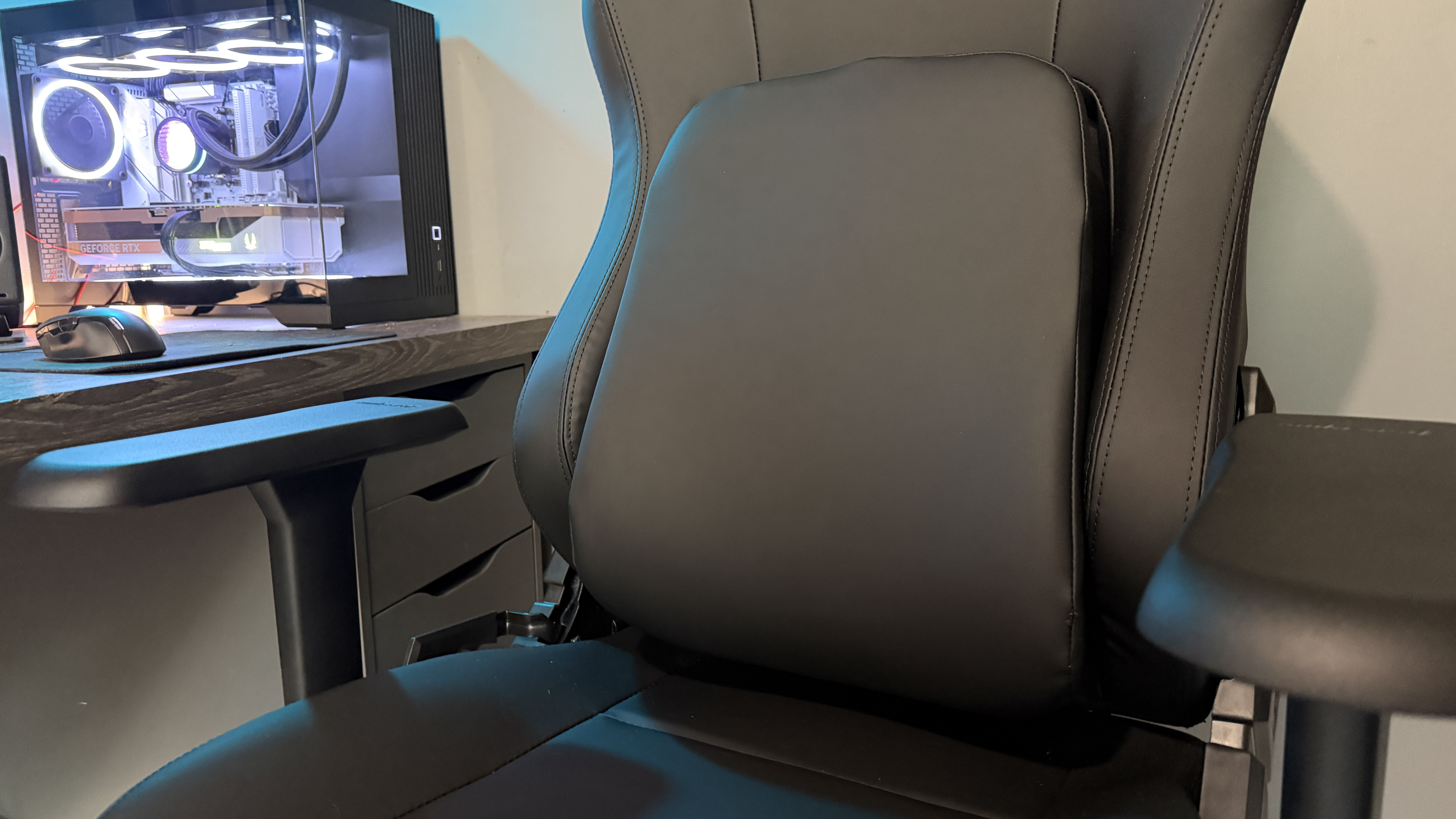 The AndaSeat Phantom 4 Pro in a brightly lit home office environment in front of a gaming PC.