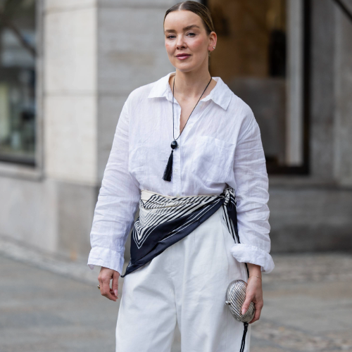 BERLIN, GERMANY - MARCH 24: Tina Haase wears white linen shirt, white barrel pants Meshki, striped scarf, tassel necklace Nakd, vintage Silver clutch bag on March 24, 2026 in Berlin, Germany. (Photo by Christian Vierig/Getty Images)