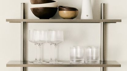 H&M Home ribbed glassware on silver shelving unit with bowls and portable lamp on the top shelf