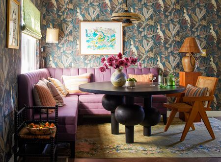 small dining area with pink bench and patterned wallpaper