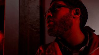 A man stands in dull red light