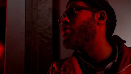 A man stands in dull red light