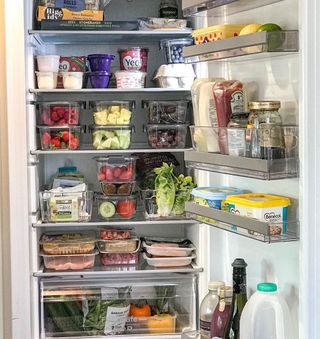 A fridge with groceries stored in organizational boxes