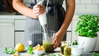 Woman using an immersion blender to create a sauce 