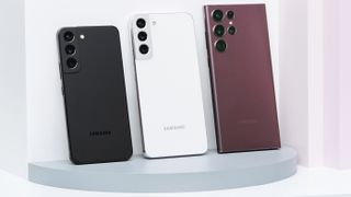 Three Samsung S22 phones leaning against a white backdrop