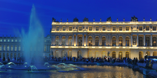 Fountain of Apollo in Versailles lit up at night.