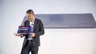 Lenovo&amp;#039;s senior vice president and general manager, Johnson Jia, on stage at CES 2020 holding a laptop