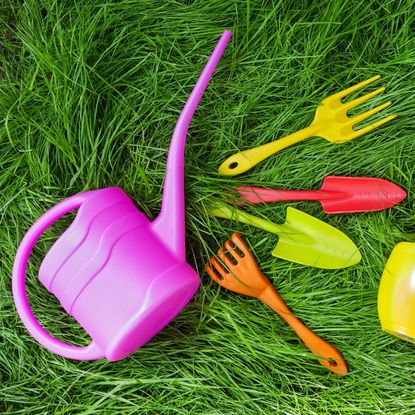 Bright plastic gardening tools on grass