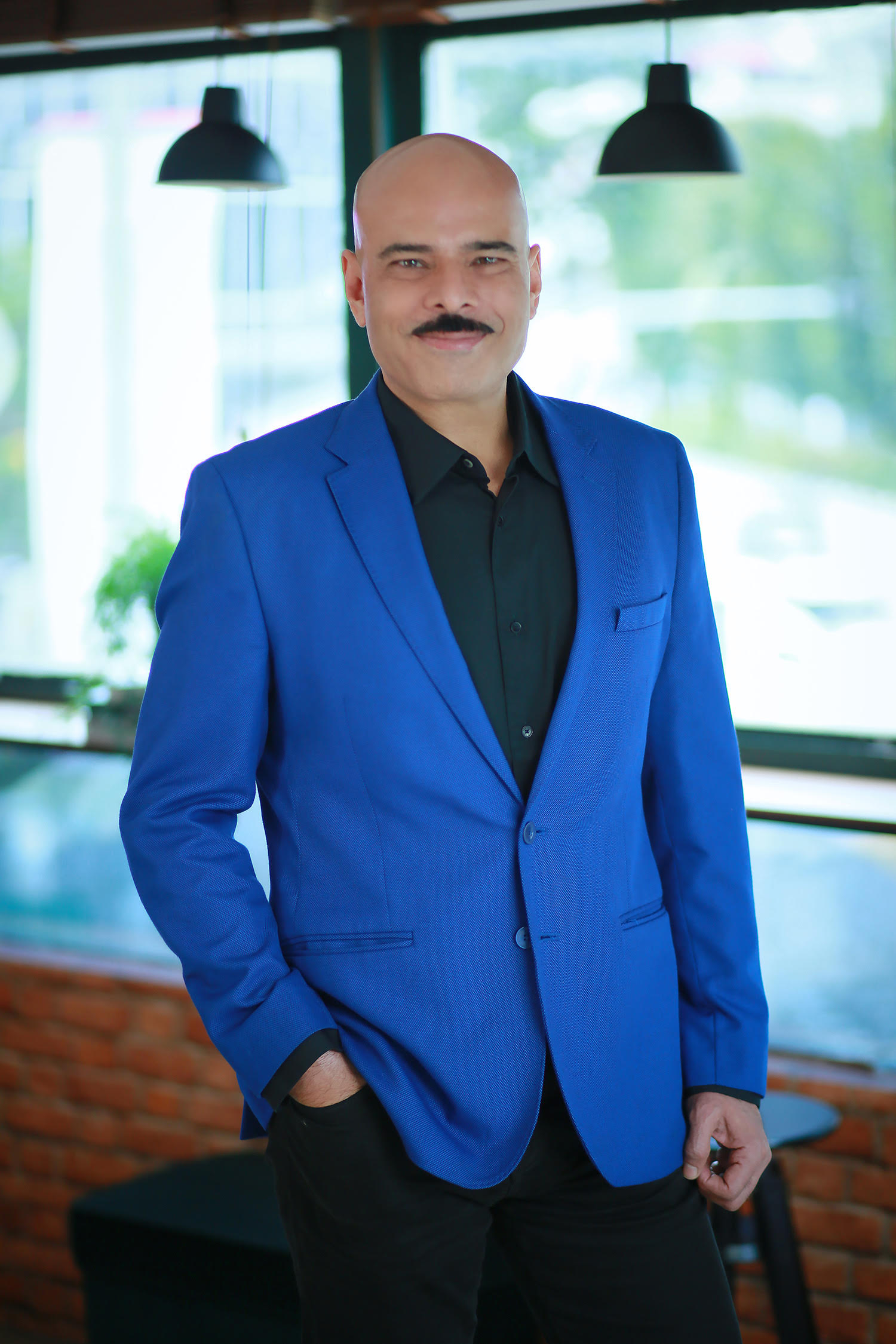 Headshot of Sandeep Mehra in a royal blue blazer.