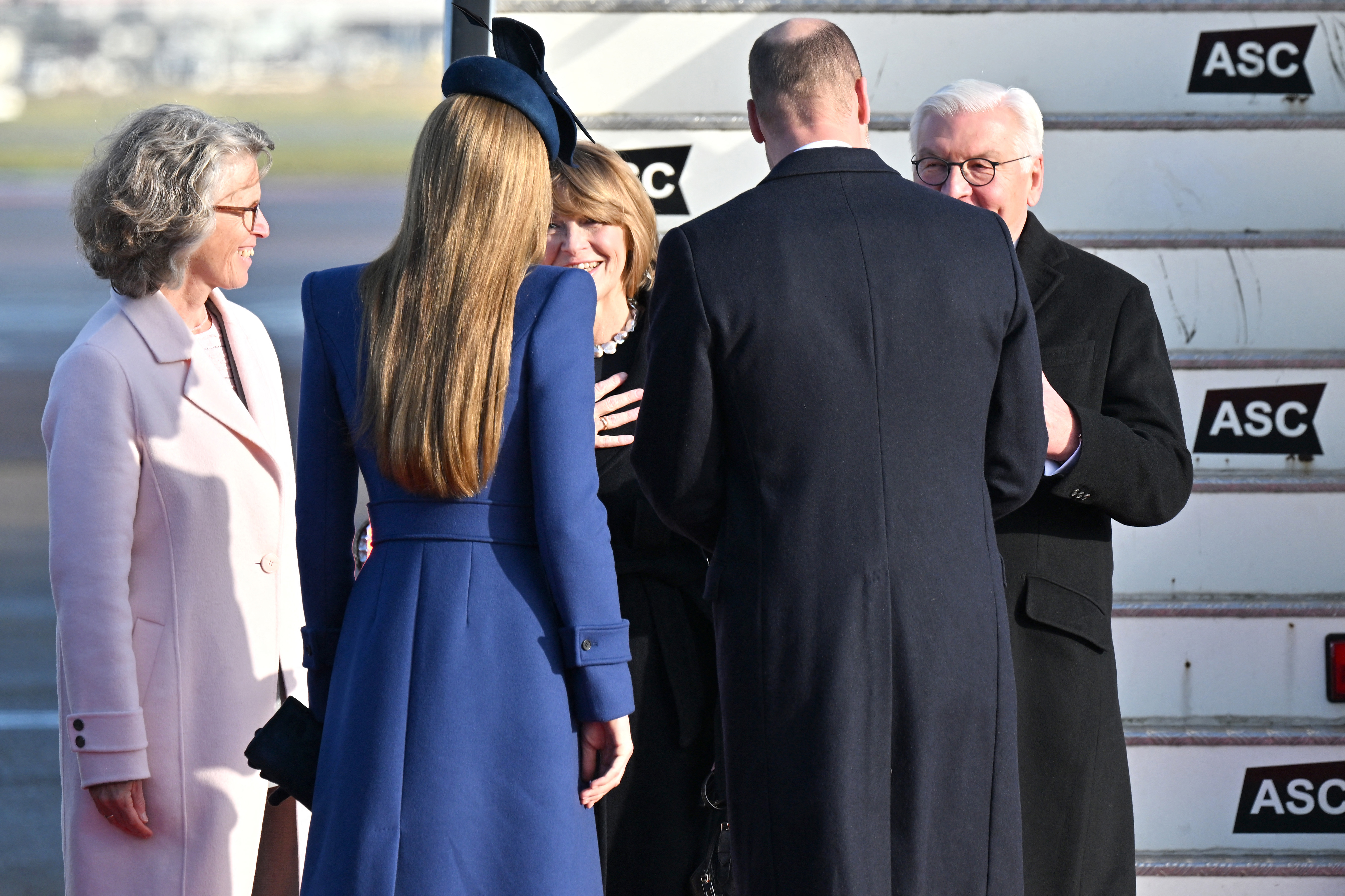 Kate Middleton and Prince William with their backs to the camera greeting the president and first lady of Germany